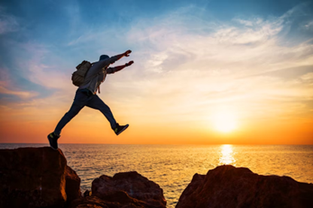 person jumping across rocks